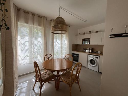 une cuisine avec une table et des chaises dans une cuisine dans l'établissement Studio Wish 5 min Disney Parking, à Chessy