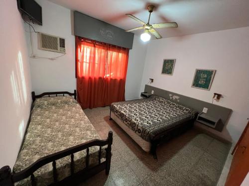 a bedroom with two beds and a red door at Cybeles Family Apart in Villa Carlos Paz