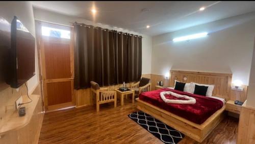 a bedroom with a bed with a red blanket at Ramblers Nest in Sissu