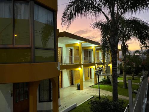 a building with a palm tree in front of it at Cybeles Family Apart in Villa Carlos Paz