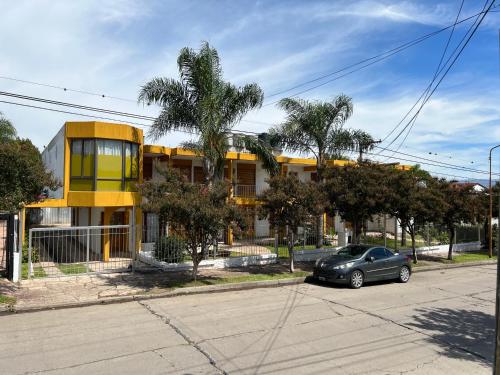 a car parked in front of a yellow building at Cybeles Family Apart in Villa Carlos Paz