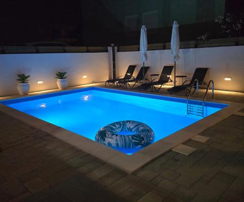 a swimming pool at night with chairs around it at Apartment Alicia with private pool in Vodice