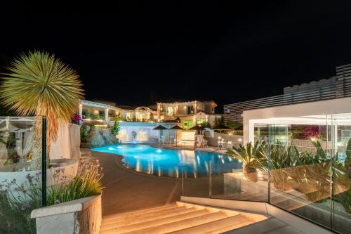 a swimming pool in a resort at night at Oasi Blu Sardinia in Santa Margherita di Pula