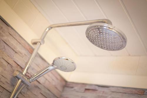 a shower with a shower head in a bathroom at Ferienwohnungen Christina Erisgen in Olderup