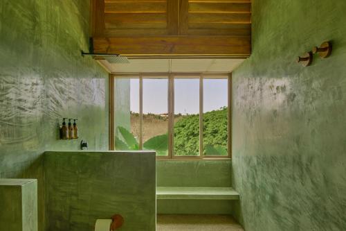 a green bathroom with a window and a tub at Punta Nayaá - Adults Only in Puerto Escondido