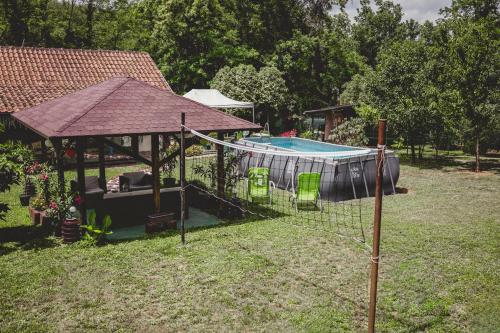 a pool with chairs and a gazebo at Vikendica Fruškogorski kutak - Fruška Gora in Čerević