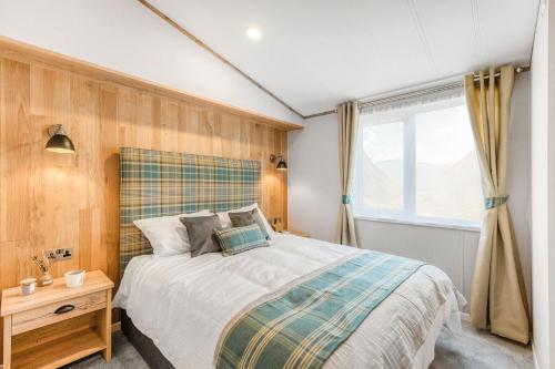 a bedroom with a large bed and a window at Aberdunant Hall in Porthmadog