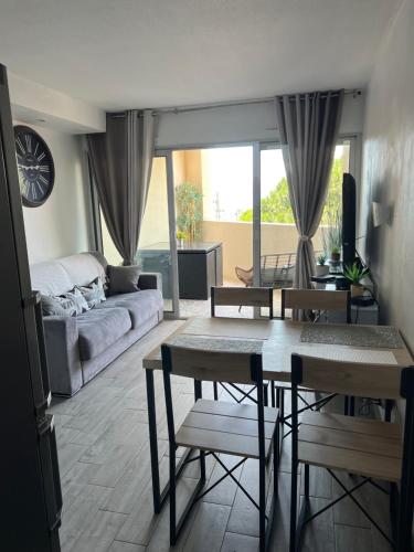 un salon avec une table, des chaises et un canapé dans l'établissement JOLI 2 PiECES AUX PIEDS DES PLAGES, à Cannes