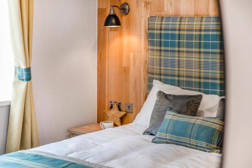 a bedroom with a bed with a plaid headboard at Aberdunant Hall in Porthmadog