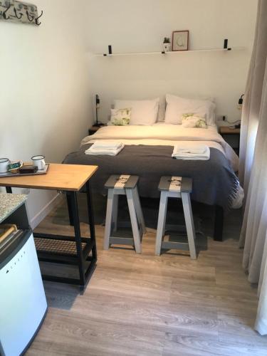 une chambre avec un lit avec deux tabourets à côté d'une table dans l'établissement Monoambiente, à San Carlos de Bariloche