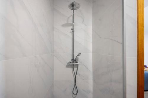 a shower with a shower head in a bathroom at Apartamento Lomi com Piscina in Apúlia