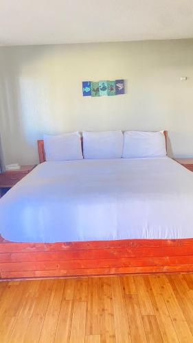 a large bed with white sheets and pillows at Ocean Shores Inn & Suites in Ocean Shores