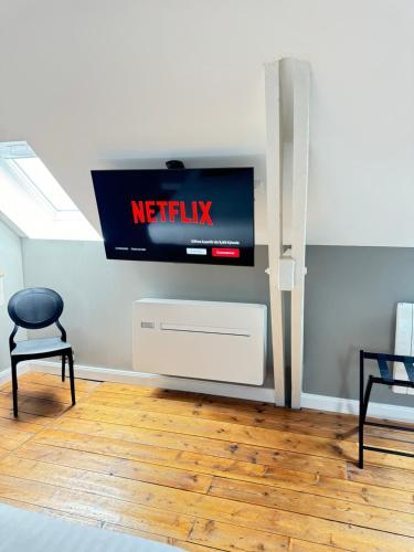 a television in a room with a chair and a table at Aura Castle in Picquigny