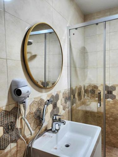 a bathroom with a sink and a mirror at Lomtadze Family Wine Hotel in Ambrolauri