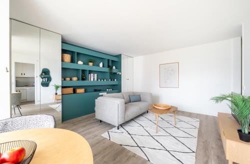 un salon avec un canapé et une table dans l'établissement Bail mobilité I La Defense et Paris en 15min, à Levallois-Perret