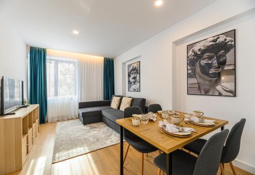 ein Wohnzimmer mit einem Tisch und einem Sofa in der Unterkunft KOA - Davino Aparthotel in Braşov