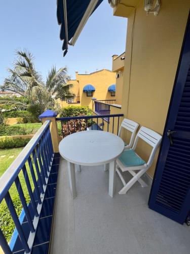 a white table and chairs on a balcony at Meloneras in Meloneras