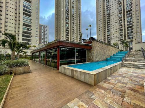 a building with a swimming pool next to tall buildings at 1606 - Luxo e Conforto na Cidade Maia in Guarulhos