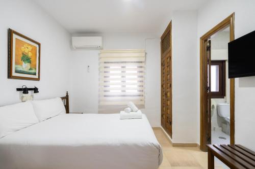 a bedroom with a white bed and a sink at Hotel La Quinta de Santillán in Chinchón