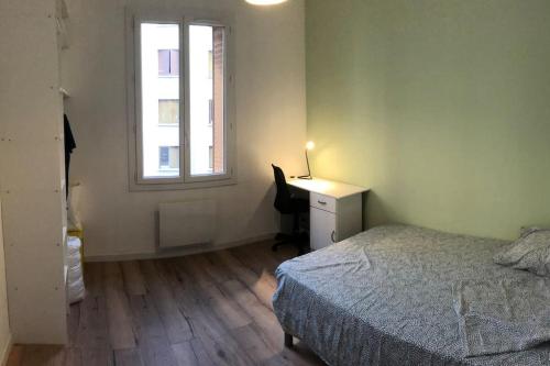 une chambre avec un lit, un bureau et une fenêtre dans l'établissement T3 refait à neuf, lumineux et confortable, à Toulon