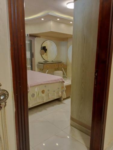 a bedroom with a bed and a large mirror at ارقي شقه فندقيه بالمنصوره واطلاله كامله علي النيل in Ṭalkha