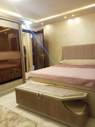 a bedroom with a large bed and a bathroom at ارقي شقه فندقيه بالمنصوره واطلاله كامله علي النيل in Ṭalkha