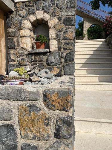 a stone wall with a potted plant on it at Apartments Klara in Sveti Juraj