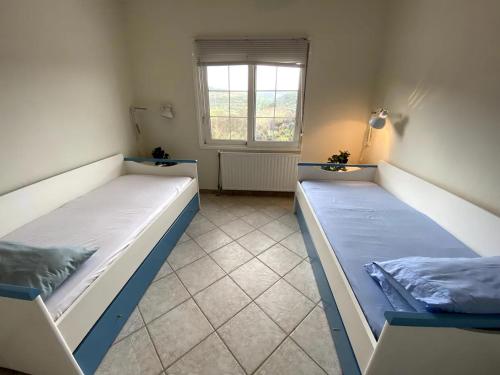 twee bedden in een kamer met een raam bij Cozy Maisonette Rebecca in Hanioti