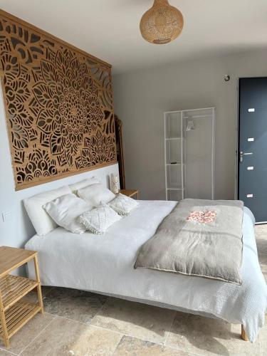 a bedroom with a large white bed and a wooden table at A Casa Vadiiolina - Chambres d'hôtes d'exception in Sollacaro