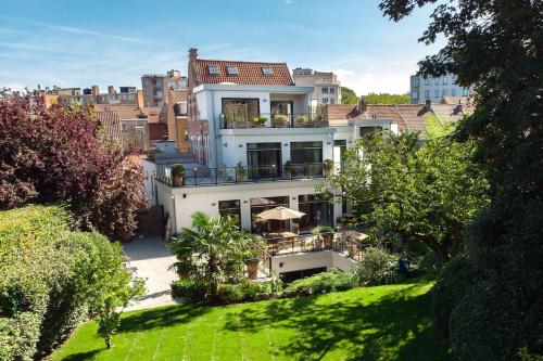 a large white building with a balcony in a city at The Retreat in Brussels
