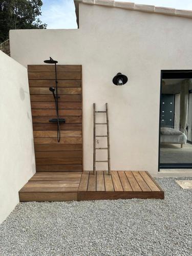 a wooden door with a ladder on the side of a house at A Casa Vadiiolina - Chambres d'hôtes d'exception in Sollacaro
