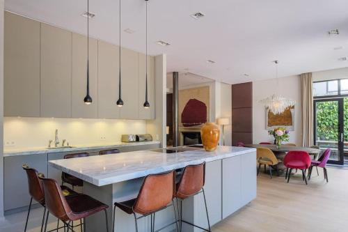 a kitchen with a large island with chairs around it at The Retreat in Brussels