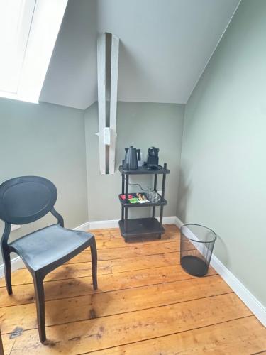 a black chair sitting on a wooden floor in a room at Aura Castle in Picquigny