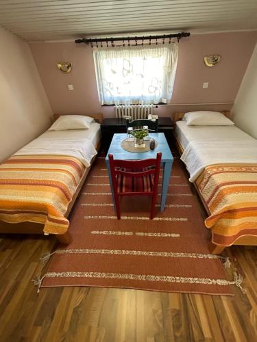 a room with two beds and a table in it at Hondo Rooms & Apartments in Sarajevo