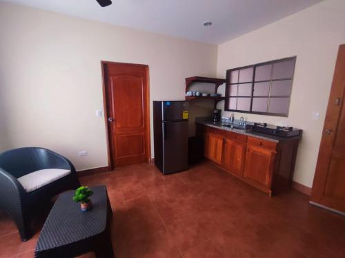 a kitchen with a black refrigerator and a table at Hotel Casona Macondo, Granada, Nicaragua in Granada