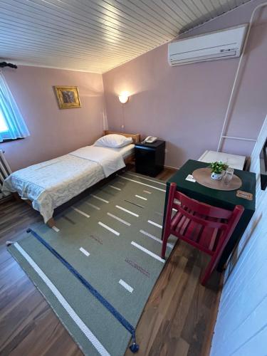 a small room with a bed and a table and a table at Hondo Rooms & Apartments in Sarajevo