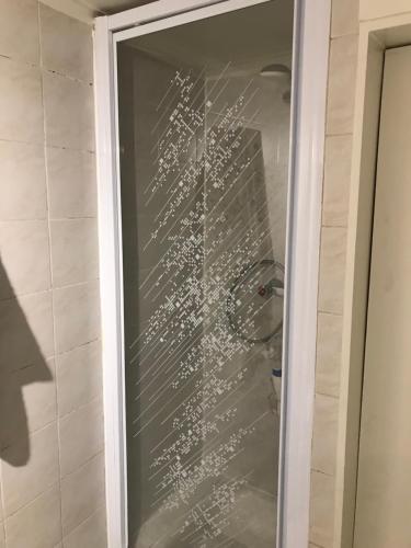 une porte de douche en verre avec une écriture blanche dessus dans l'établissement Joli Cocon Paris 15ème, à Paris