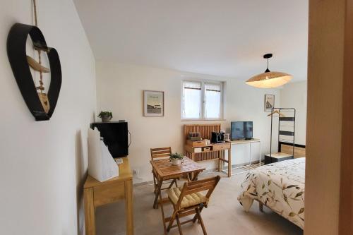 une chambre avec un lit, une table et des chaises dans l'établissement Au cœur de Catillon, à Catillon