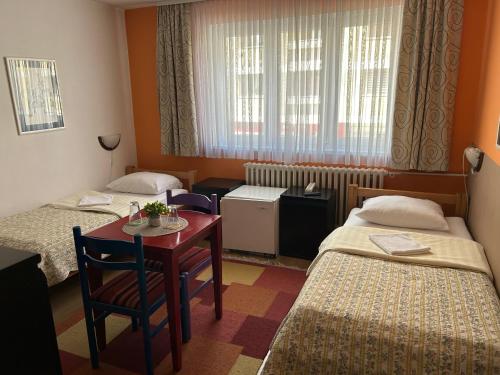 a hotel room with two beds and a table and a desk at Hondo Rooms & Apartments in Sarajevo