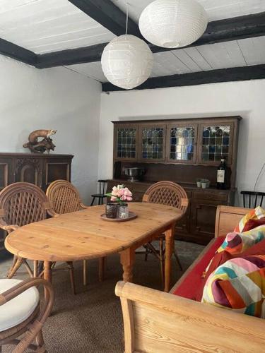 a dining room with a wooden table and chairs at Charming rustic barn close to Tisvilde in Helsinge