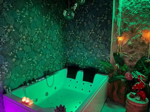 a green bath tub in a bathroom with green wallpaper at Mary Gery's Rooms in Castellammare del Golfo