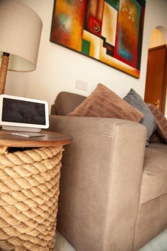 a laptop sitting on top of a couch with a table at Roussev Apartment - Coastal Gem - Anzio in Anzio