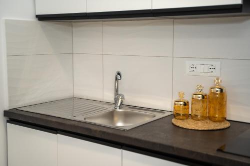 a kitchen counter with a sink and two bottles at Sunnydream Apartaments Saranda in Sarandë