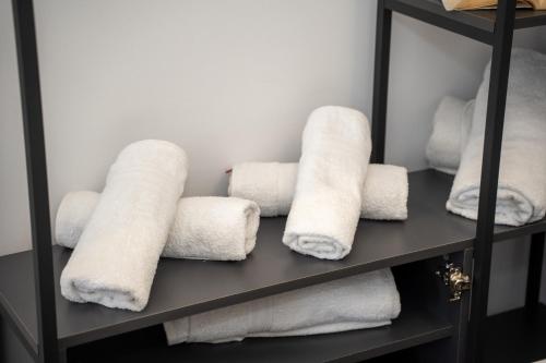 a shelf filled with white towels in a bathroom at Sunnydream Apartaments Saranda in Sarandë