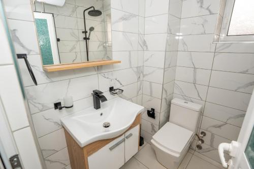 a bathroom with a sink and a toilet at Sunnydream Apartaments Saranda in Sarandë