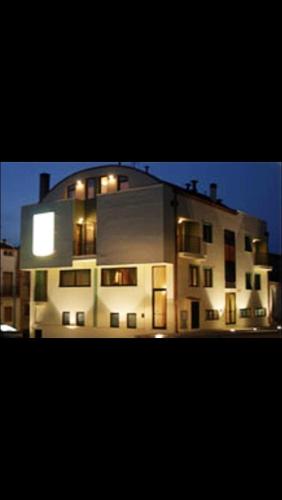 a large white building with its lights on at Alma Hotel San Giorgio in San Giorgio Lucano
