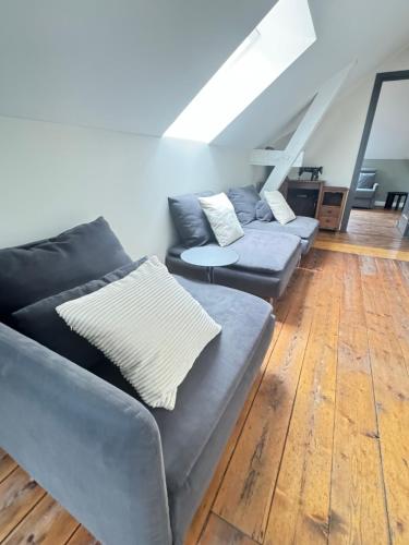 a living room with two couches and a wooden floor at Aura Castle in Picquigny
