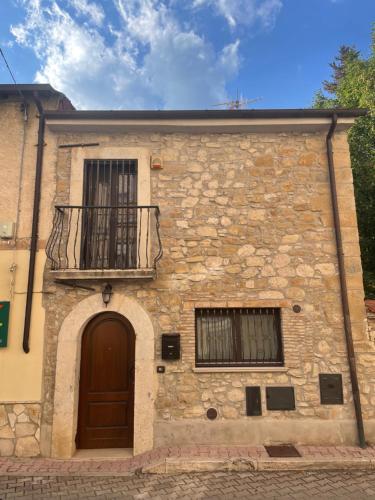 a stone building with a door and a balcony at 18th Century Samnium Stone Residence in Alfedena