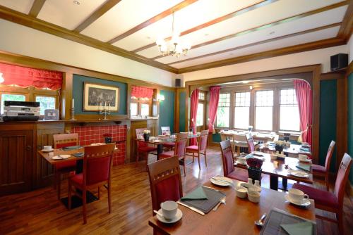 a dining room with wooden tables and chairs at Rivendell in Dumfries