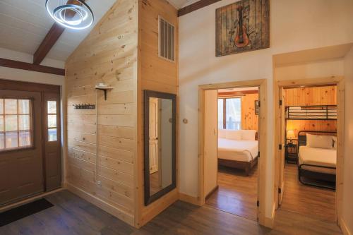 Zimmer mit einer Holzwand und einem Schlafzimmer in der Unterkunft Fabulous 4Bed 3 bath Cottage Pool Hot tub Games in Gatlinburg